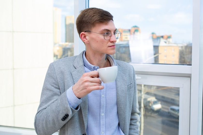 An afternoon desk by a window with a notebook and a glass of water